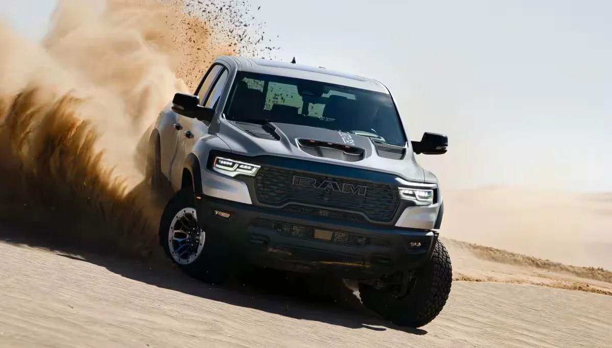 A Ram 1500 RHO kicking up sand as it drives through the desert.