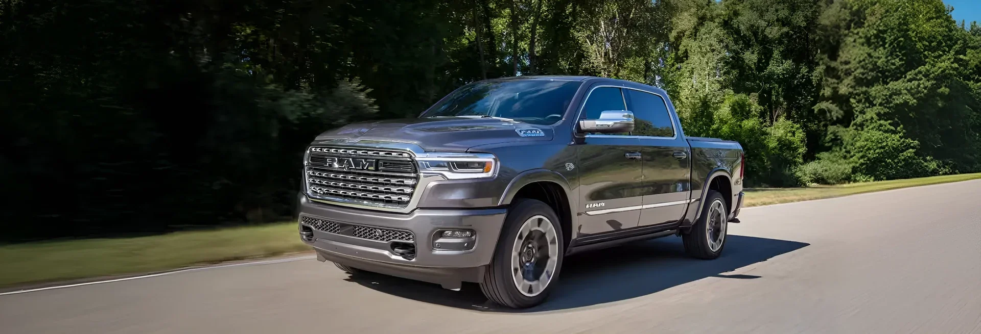 A grey 2026 Ram 1500 on a tree-lined road.