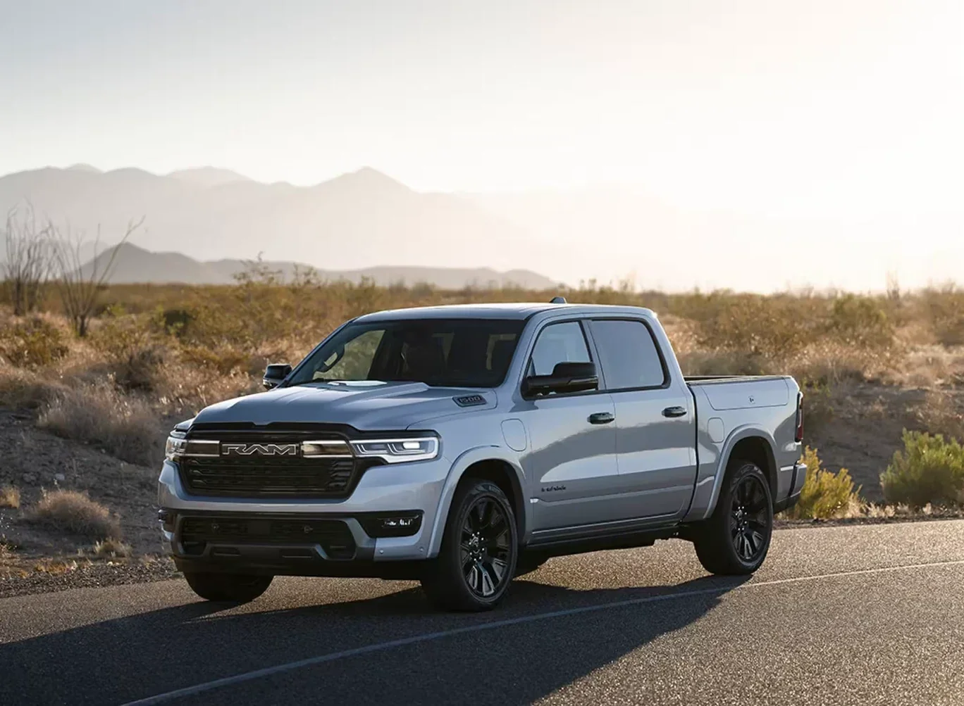 A silver 2027 Ram 1500 REV on a desert road.