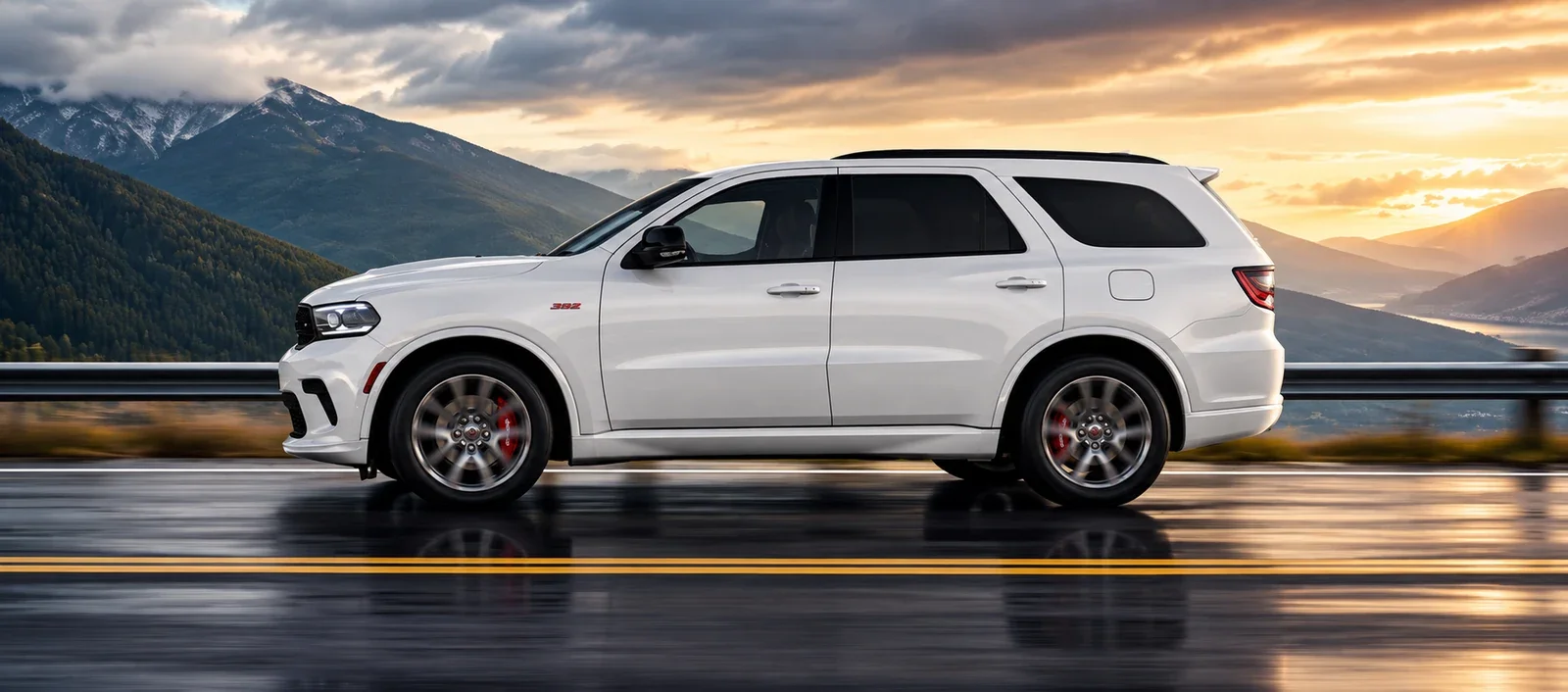 A white Dodge Durango driving on a mountain road at sunset, photographed from the side.
