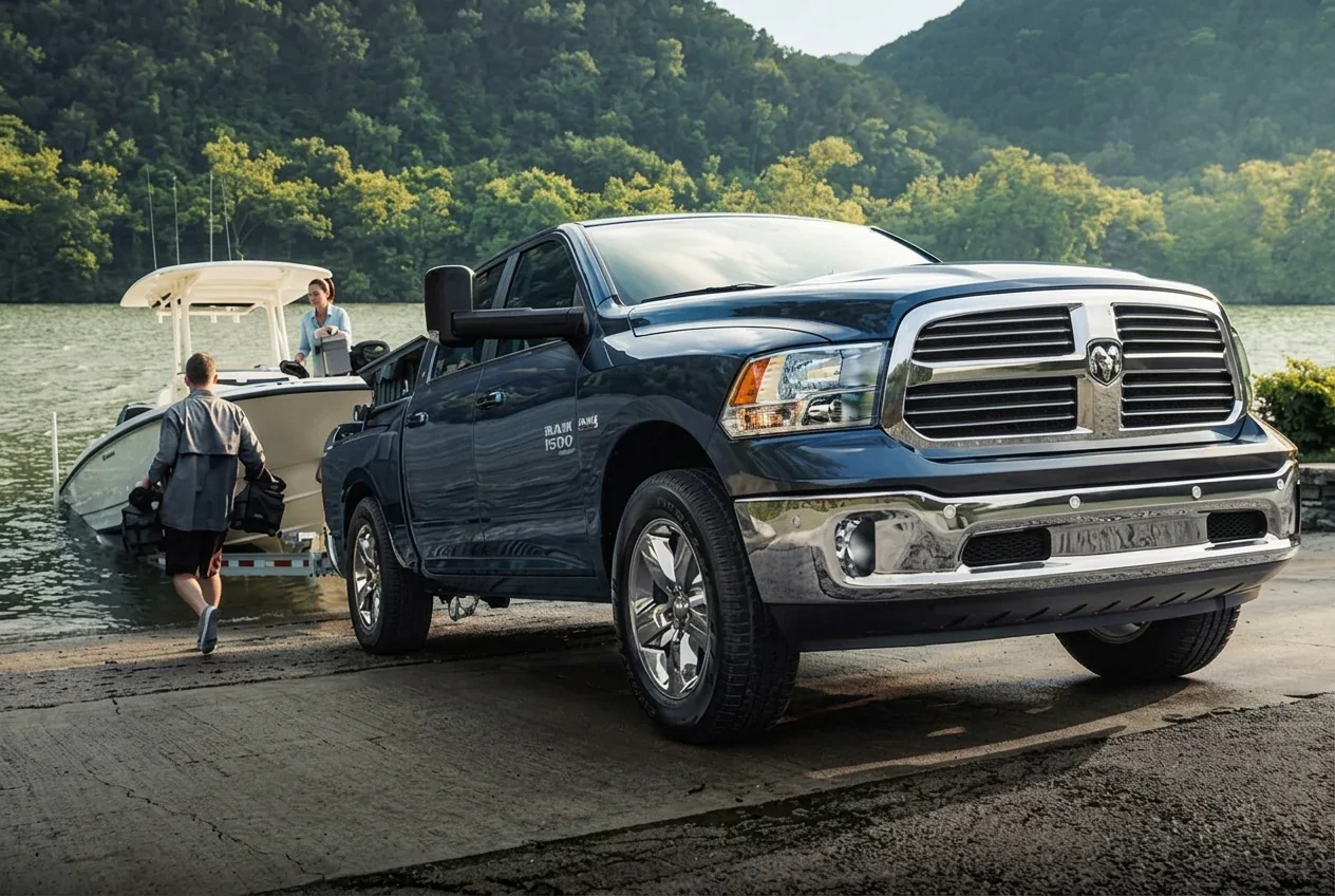 A Ram 1500 backing a boat down a launch ramp.