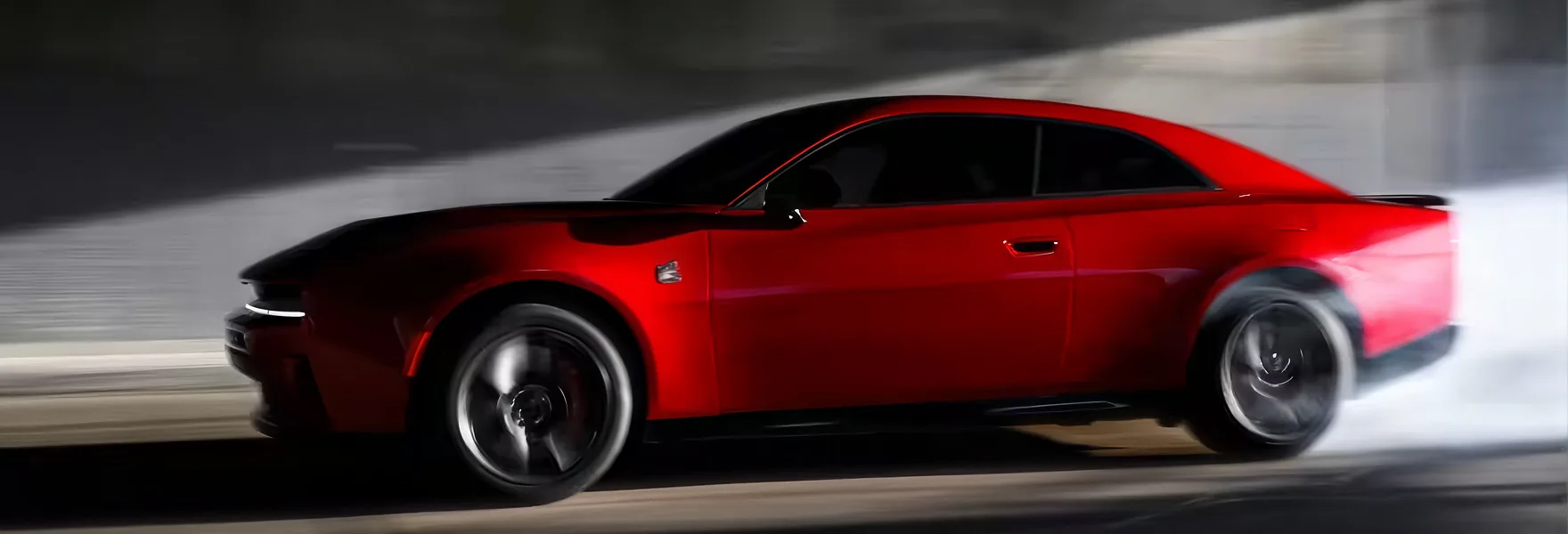 Red 2026 Dodge Charger driving fast in profile against a motion-blurred wall