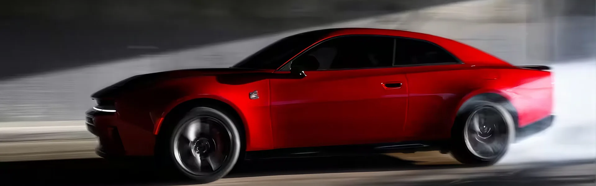 Red 2026 Dodge Charger driving fast in profile against a motion-blurred wall