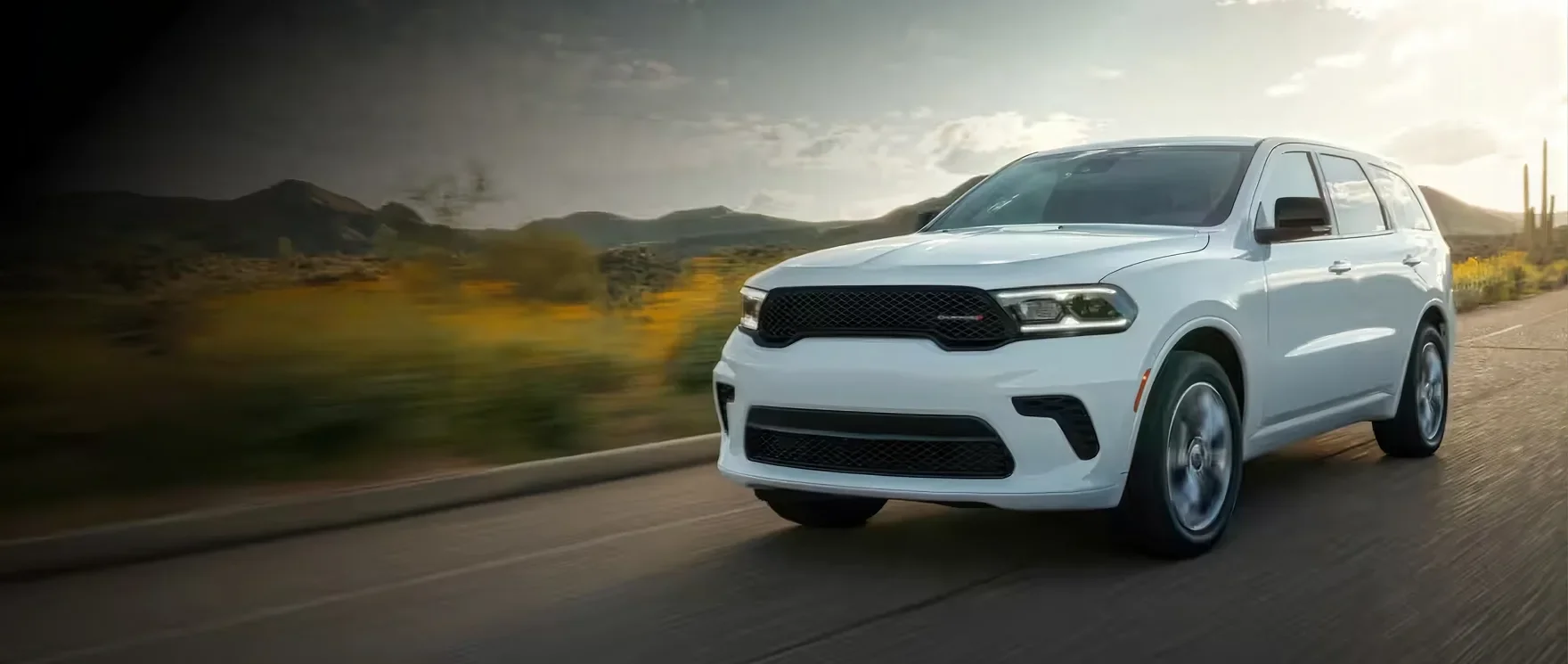 White Dodge Durango GT driving on an open road through dry hills