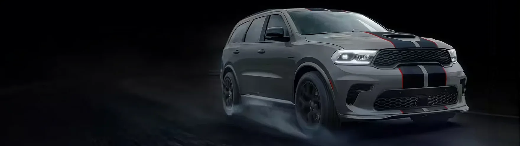 Grey Dodge Durango with black stripes seen head-on against a dark background