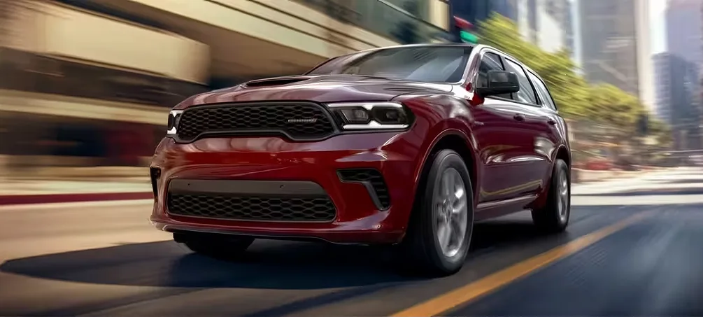Red Dodge Durango driving toward the camera on a city road