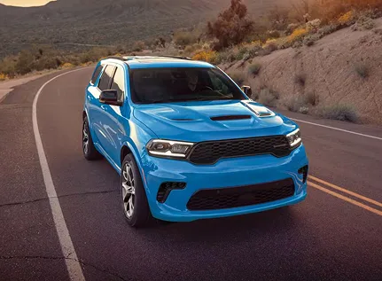 Blue Dodge Durango on a mountain road, front three-quarter view