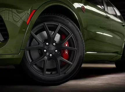 Close-up of an olive Dodge Durango wheel with a red brake caliper