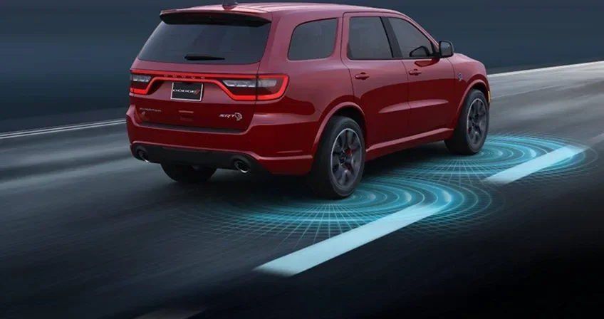 Red Dodge Durango on a highway with blue lane-marking graphics