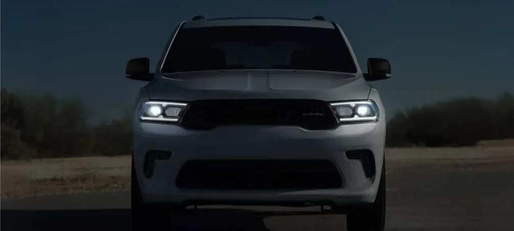 White Dodge Durango head-on at night with its LED headlights lit