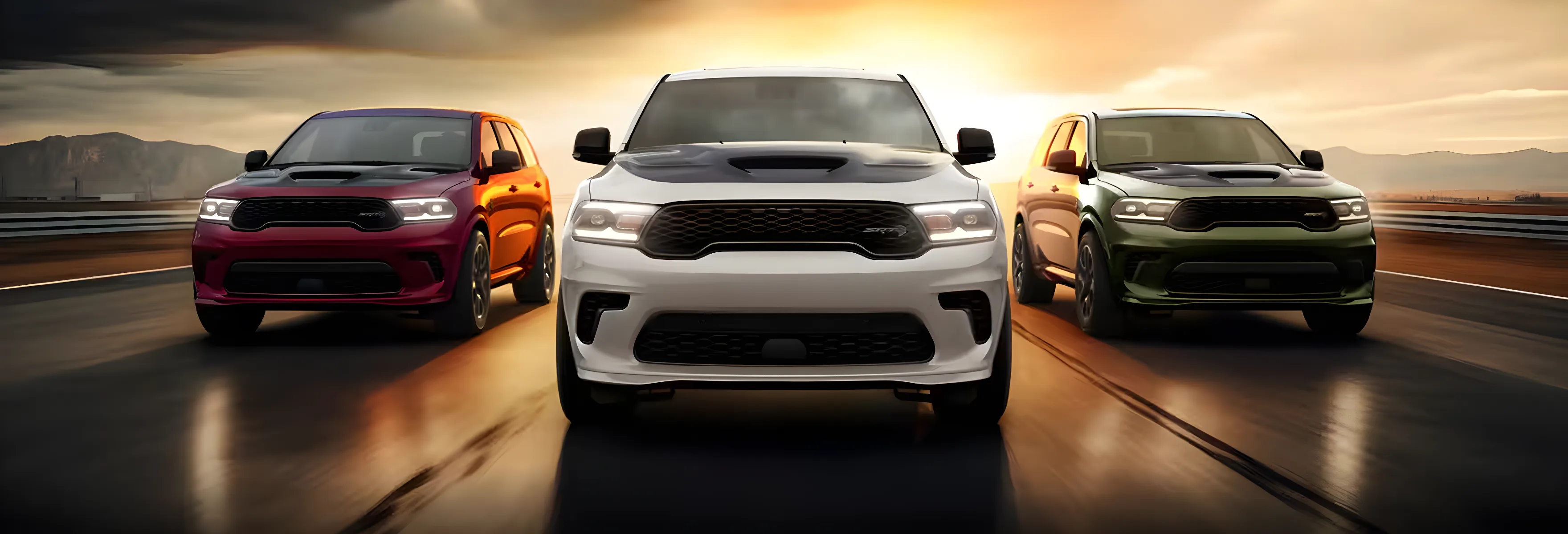 Red, black and olive Dodge Durango models lined up head-on at sunset