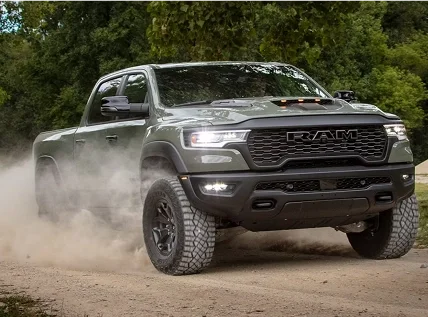 Green RAM 1500 RHO driving fast over dirt with dust behind it