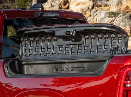 Open RamBox storage bin on the bed side of a red RAM 1500