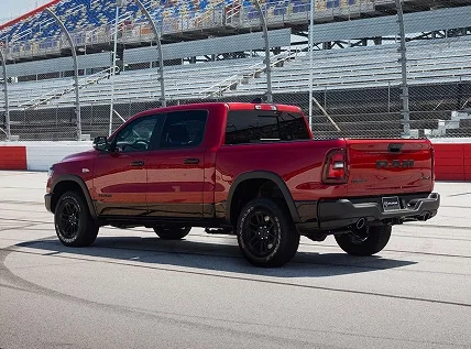 Red RAM 1500 parked at a race circuit, rear three-quarter view