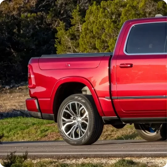 Red RAM 1500 parked beside a rock face showing the RamBox bed sides