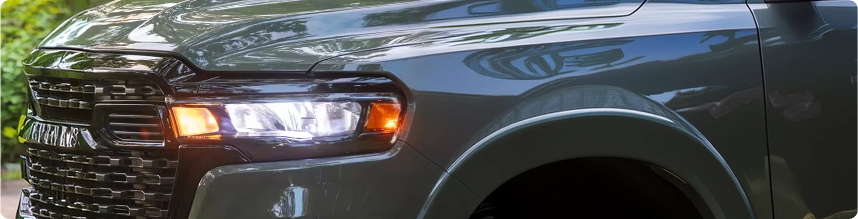Close-up of the RAM 1500 LED headlamp and grille lit at night