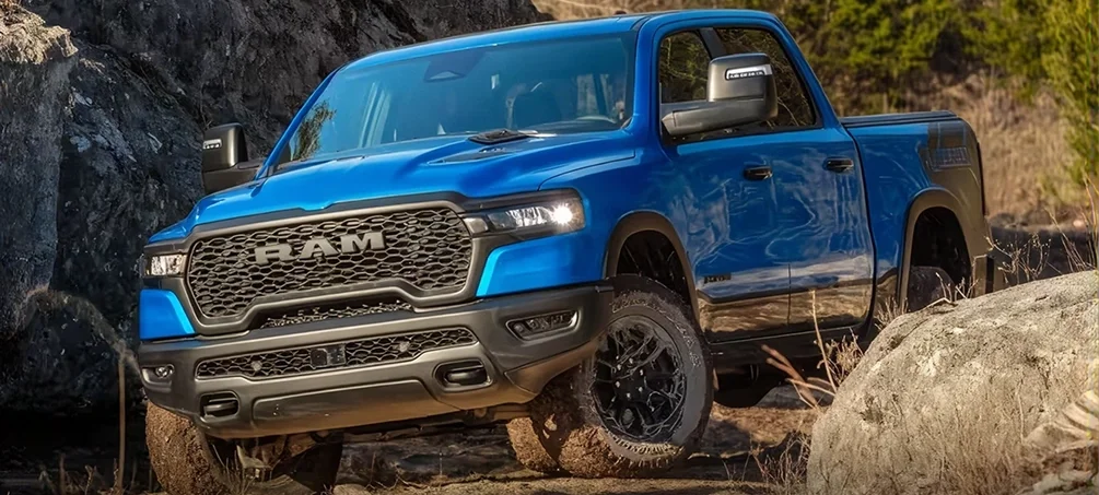 Blue RAM 1500 Rebel crawling over rocks on an off-road trail