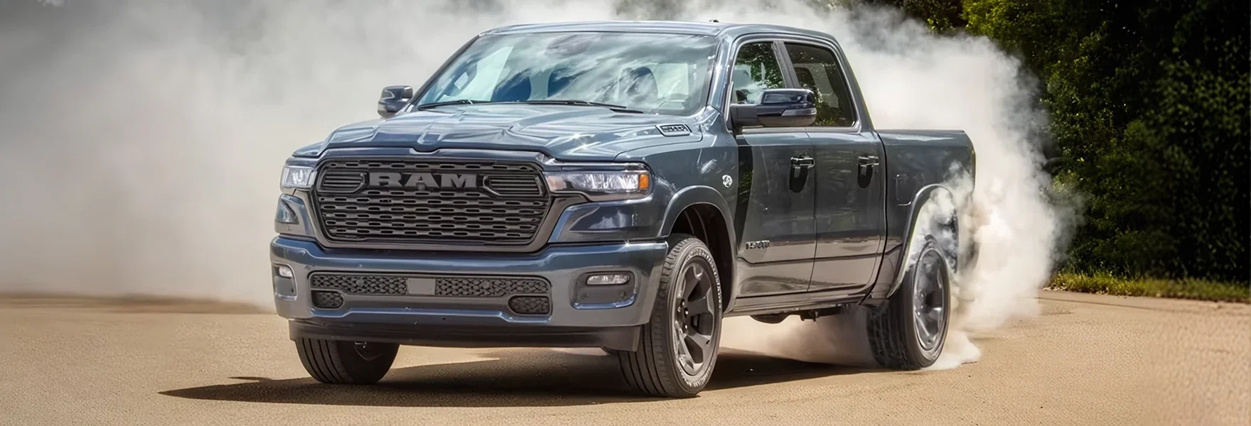 Blue RAM 1500 crew cab pickup doing a burnout on a paved lot with tire smoke behind it