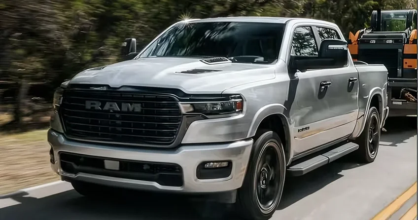 White RAM 1500 backing up to a flatbed trailer on a paved lot