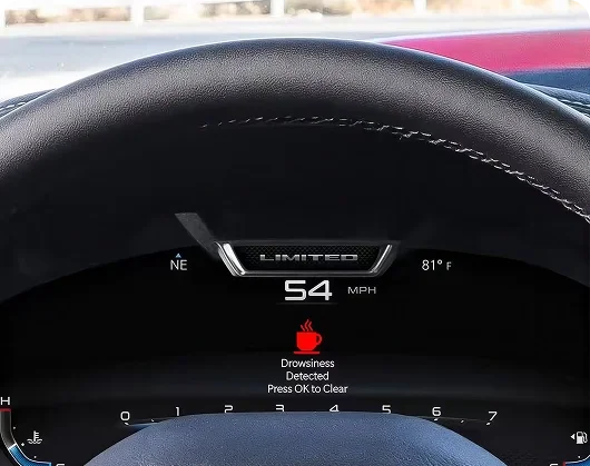RAM digital cluster displaying a Drowsiness Detected coffee cup alert at 54 mph