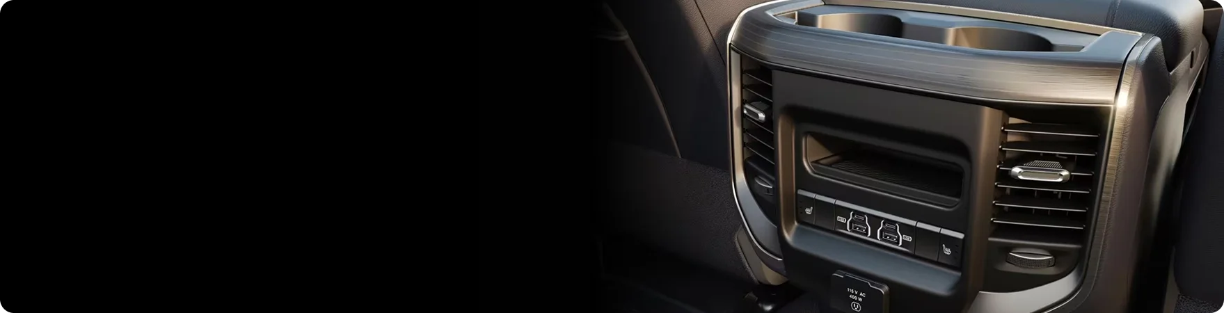 Rear of the RAM 2500 centre console showing air vents, USB ports and the 115-volt outlet