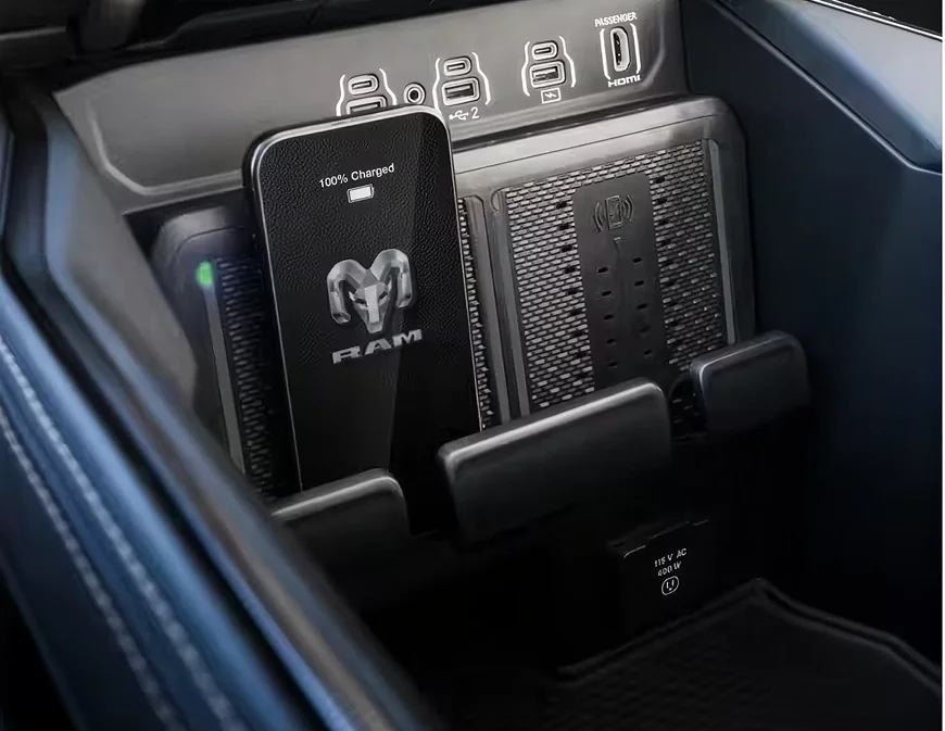 Two smartphones charging upright on the dual wireless charging pads in the RAM 2500 console