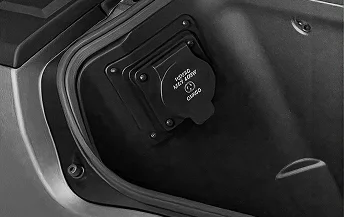 Open RamBox side storage bin showing the moulded interior and 115-volt power outlet