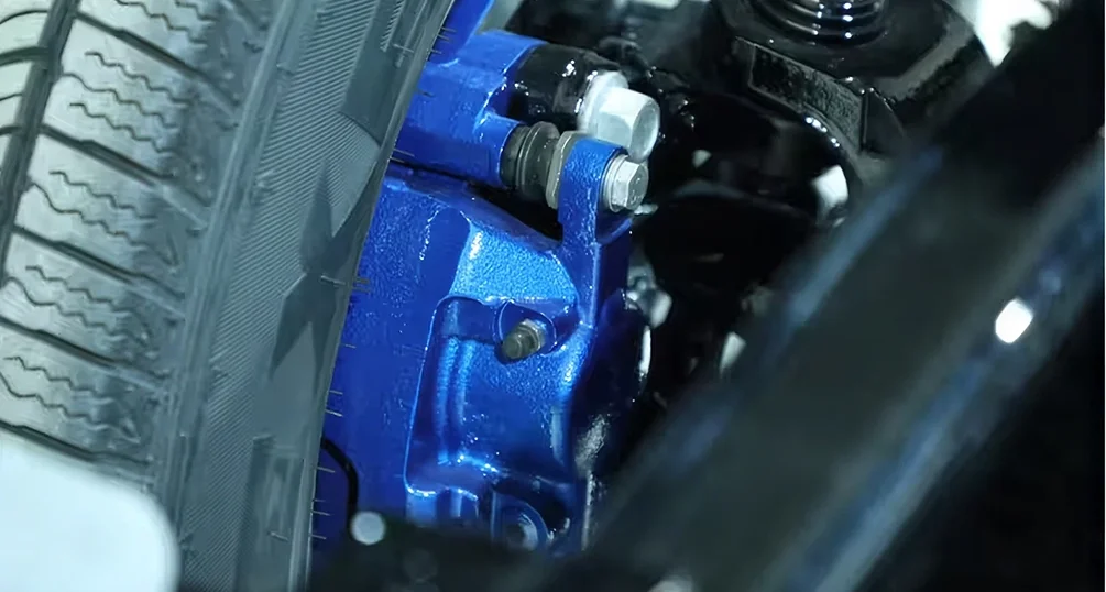 Close-up of a blue-painted brake caliper and rotor behind the wheel of a RAM 2500