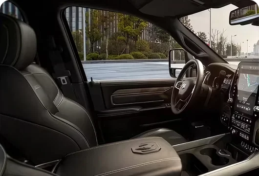 RAM 2500 Laramie interior with black leather-trimmed seats and a wood-accented dashboard