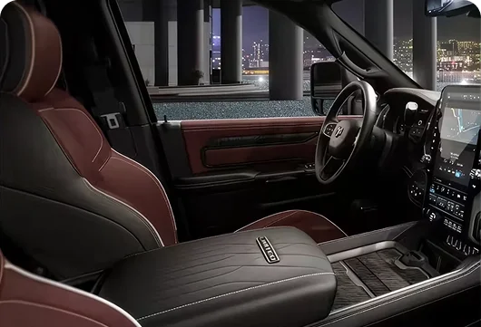 RAM 2500 Limited interior with black and burgundy leather seats and a wood-trimmed dashboard