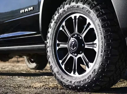 Close-up of a polished alloy wheel and all-terrain tire on a black RAM 2500