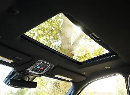 Open panoramic sunroof of a RAM 2500 with trees visible above
