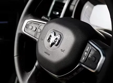 Close-up of the RAM 2500 steering wheel with the ram head badge and control buttons