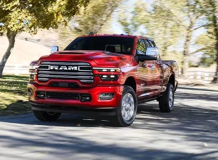 Red RAM 2500 parked beside a white ranch fence with trees behind it