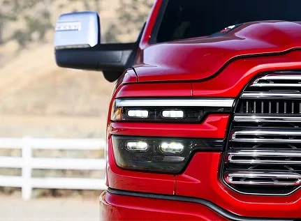 Close-up of the chrome grille and LED headlamp of a red RAM 2500