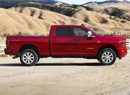 Red RAM 2500 crew cab shown in profile on gravel with golden hills behind