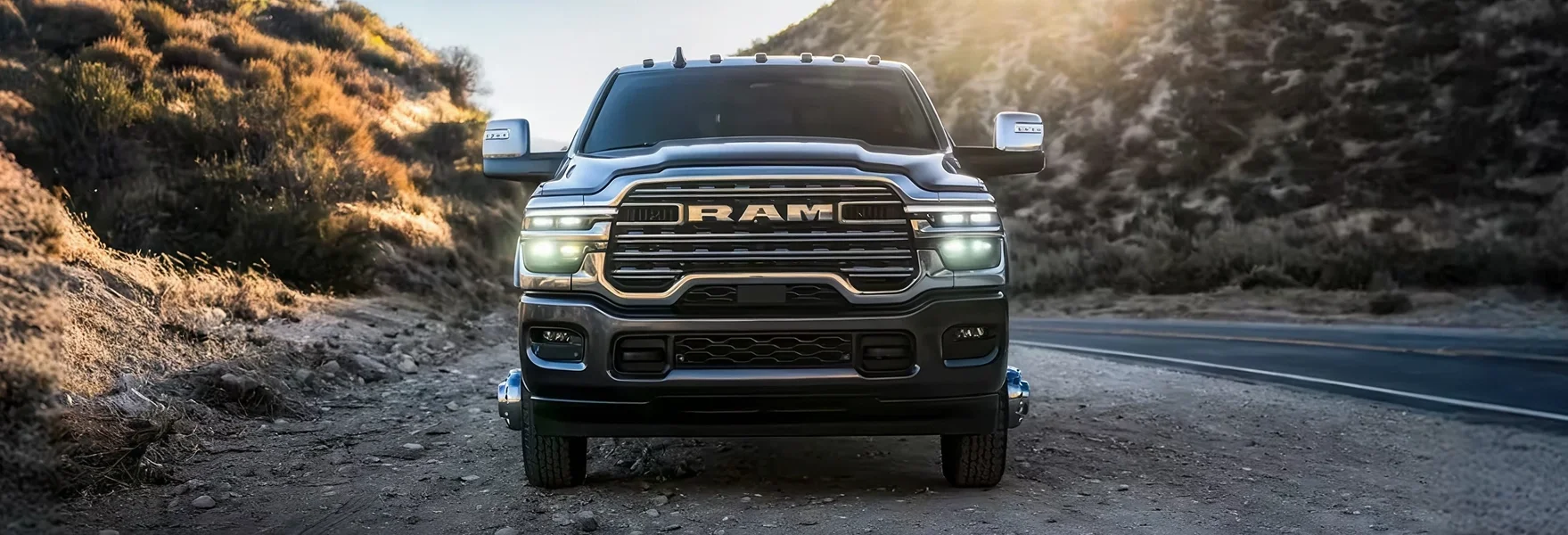 Dark RAM 3500 shown head-on driving a mountain road at dusk