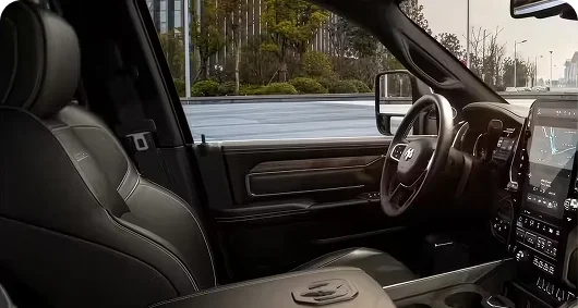 RAM 3500 Laramie interior with black leather-trimmed seats and a wood-accented dashboard