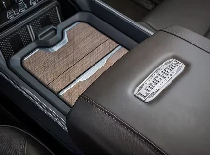 Wood-inlay center console lid with a Longhorn Edition badge beside a matching leather seatback