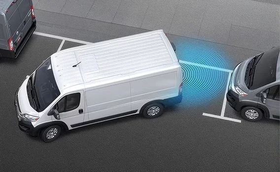 Aerial view of a white RAM ProMaster van reversing near a parked car with blue sensor graphics