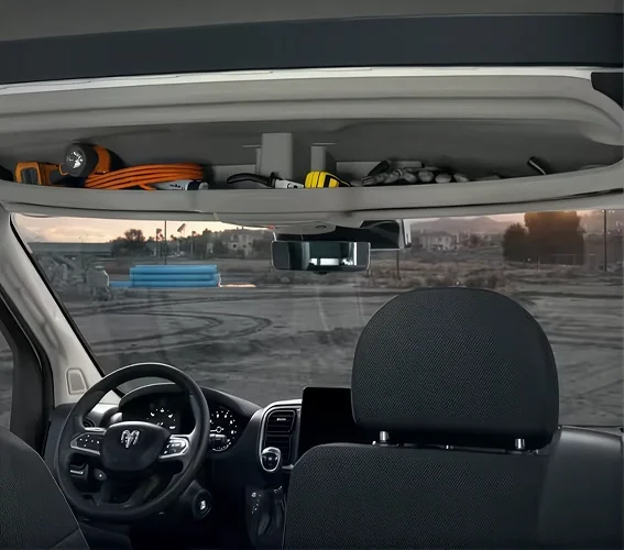 Tools and gear stored in the overhead headliner storage of a RAM ProMaster cabin