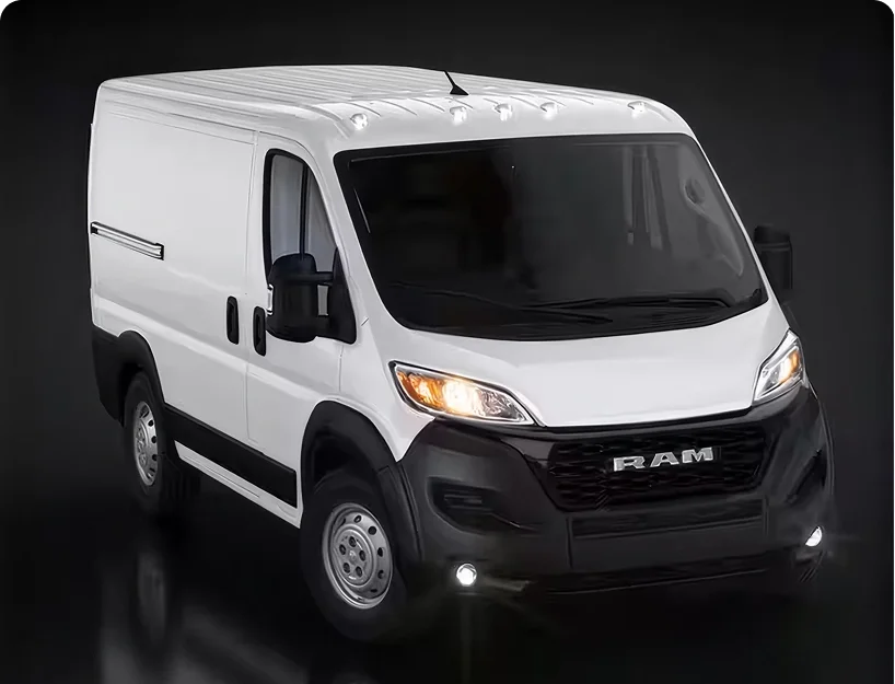 White RAM ProMaster cargo van with halogen headlamps illuminated in a dark studio