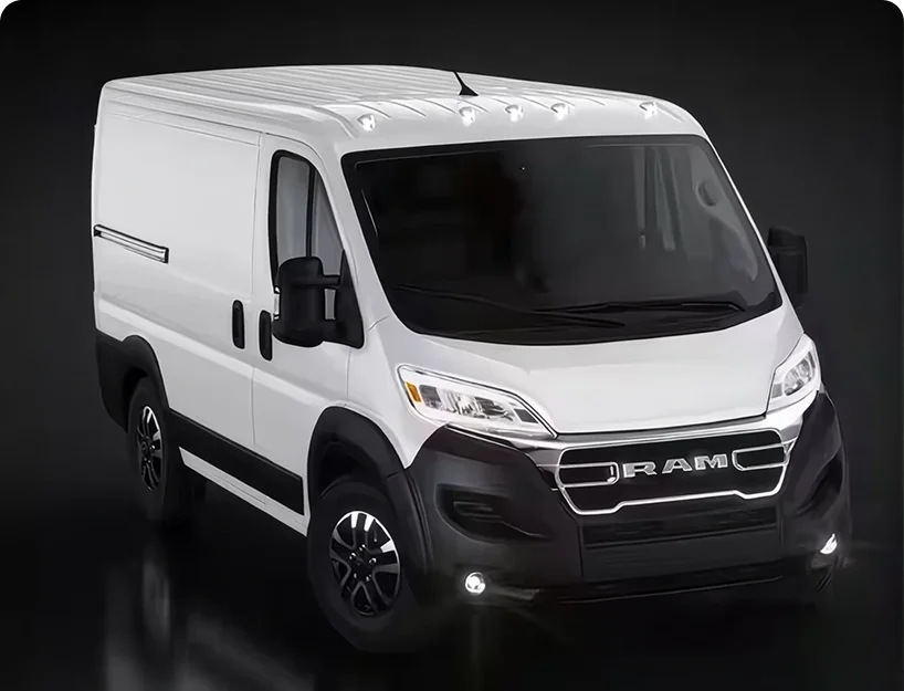 White RAM ProMaster cargo van with LED headlamps and fog lamps illuminated in a dark studio