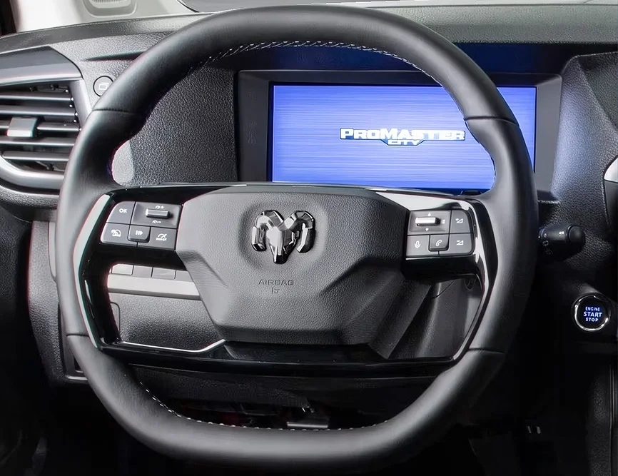 RAM ProMaster City steering wheel with the ram head badge in front of a blue touchscreen showing the ProMaster City logo