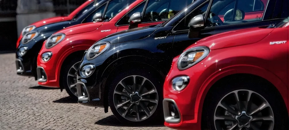 Row of red and black FIAT 500X models lined up in a showroom