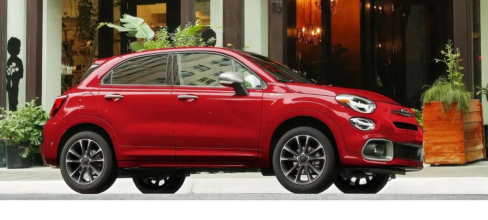 Red FIAT 500X parked on a city street outside a storefront