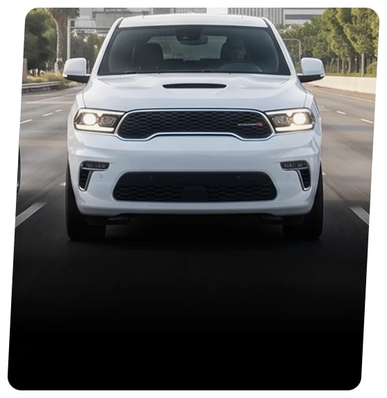 White Dodge Durango SUV driving past a city skyline