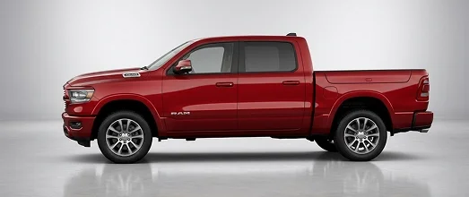 Red RAM 1500 crew cab pickup shown in profile on a studio floor