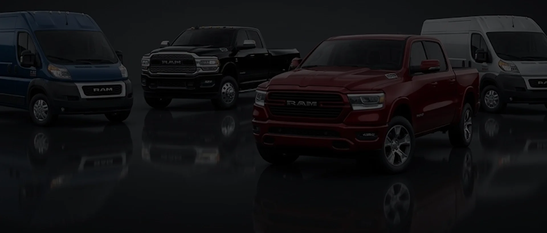 RAM ProMaster vans and RAM pickups lined up on a dark reflective floor